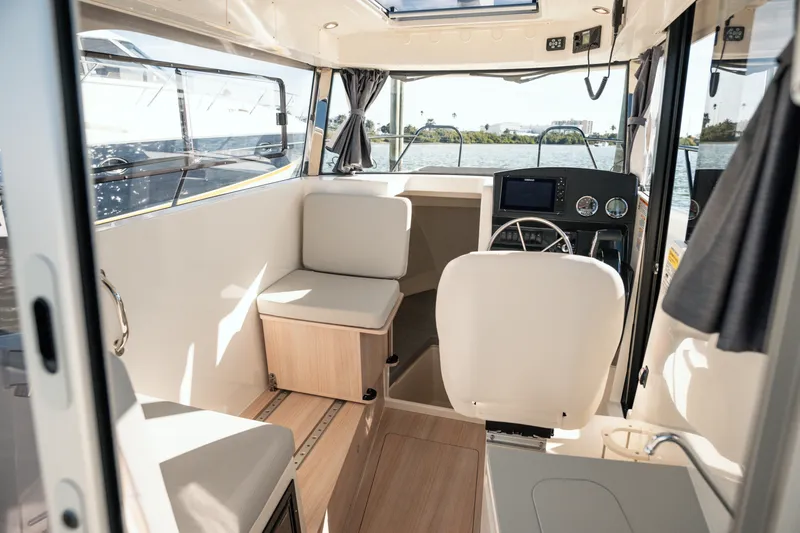 Slide: The Image of 2024 Bayliner Trophy T25 Pilothouse interior with modern helm and seating. - 4