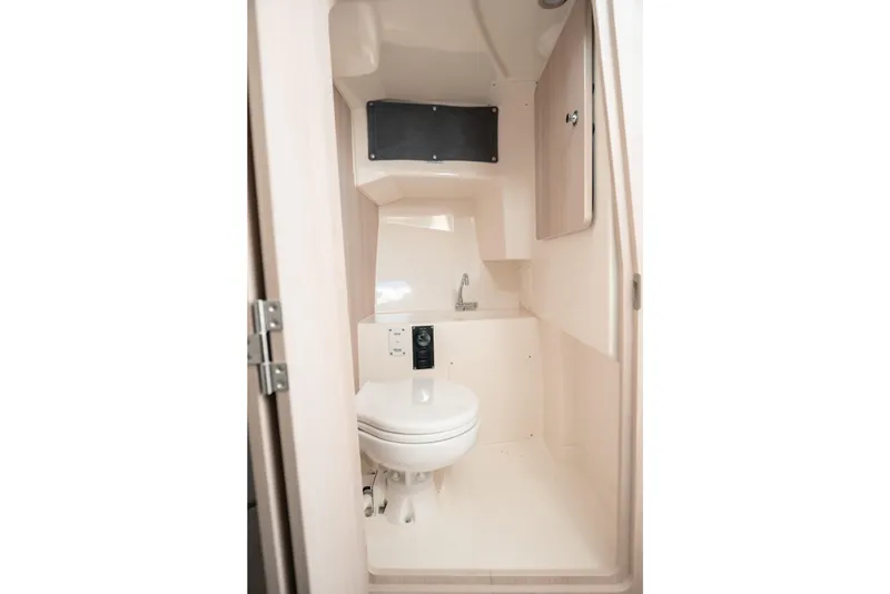 Slide: The Image of 2024 Bayliner Trophy T25 Pilothouse bathroom interior with toilet and sink. - 8