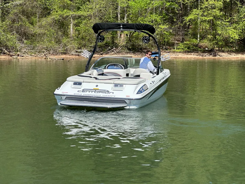 Slide: The Image of 2012 Centurion Enzo SV230 boat cruising on a serene lake with lush green surroundings. - 10