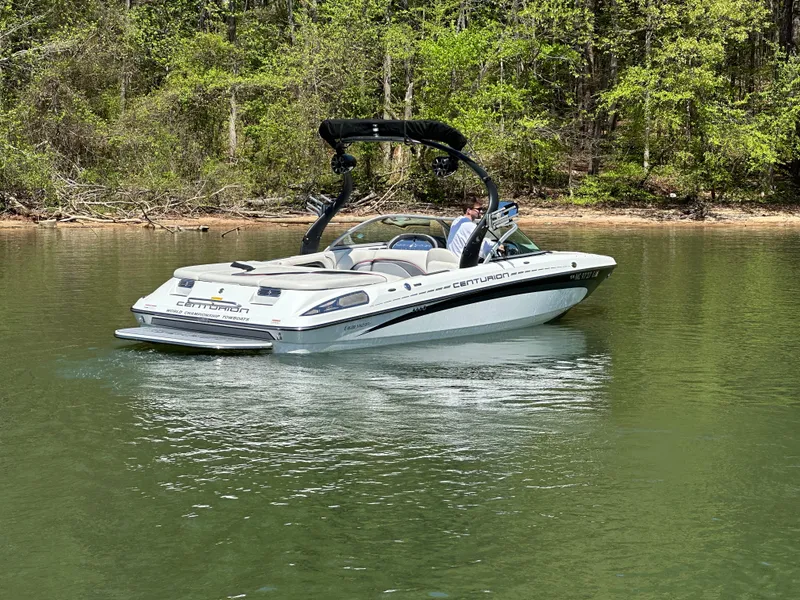 Slide: The Image of 2012 Centurion Enzo SV230 boat cruising on a serene lake with lush green surroundings. - 11