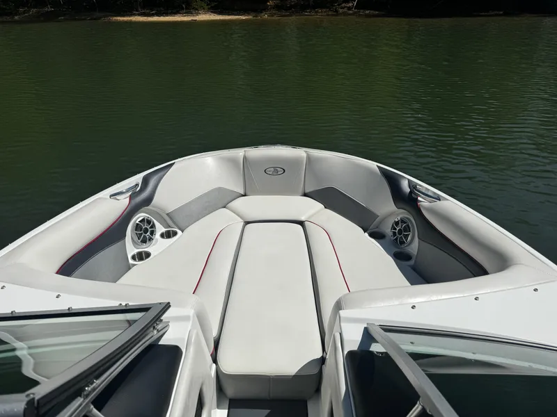 Slide: The Image of 2012 Centurion Enzo SV230 boat interior with cushioned seating and speakers on a calm lake. - 15