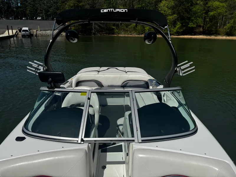 Slide: The Image of 2012 Centurion Enzo SV230 boat on calm lake water, featuring sleek design and spacious seating. - 16