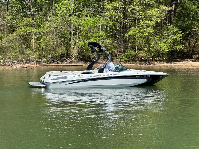 Slide: The Image of 2012 Centurion Enzo SV230 boat on a calm lake with a forested background. - 6