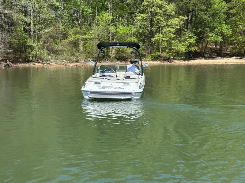Slide: The Image of 2012 Centurion Enzo SV230 boat cruising on a calm lake near a wooded shoreline. - 9