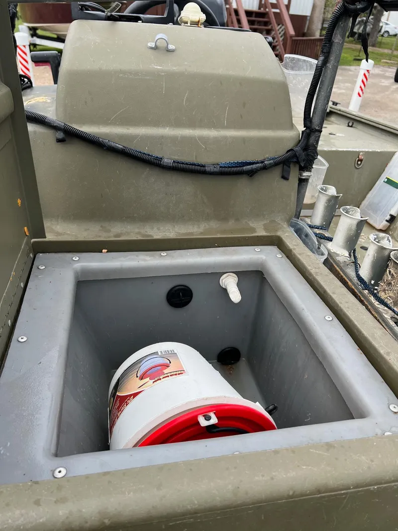 Slide: The Image of 2017 Tracker Grizzly 1648 boat interior with storage compartment and bucket. - 10