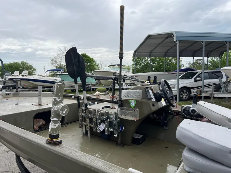 Slide: The Image of 2017 Tracker Grizzly 1648 boat with equipment, parked under cloudy skies. - 6