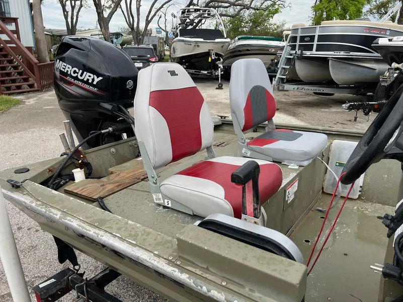 Slide: The Image of 2017 Tracker Grizzly 1648 boat with Mercury outboard motor and red-gray seating. - 8