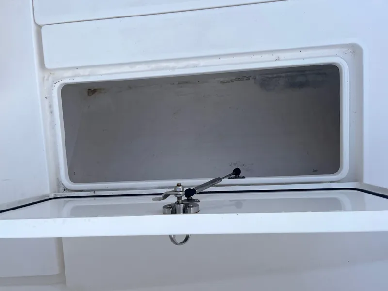 Slide: The Image of Storage compartment on a 2016 Contender 35 ST boat, featuring a secure latch mechanism. - 19