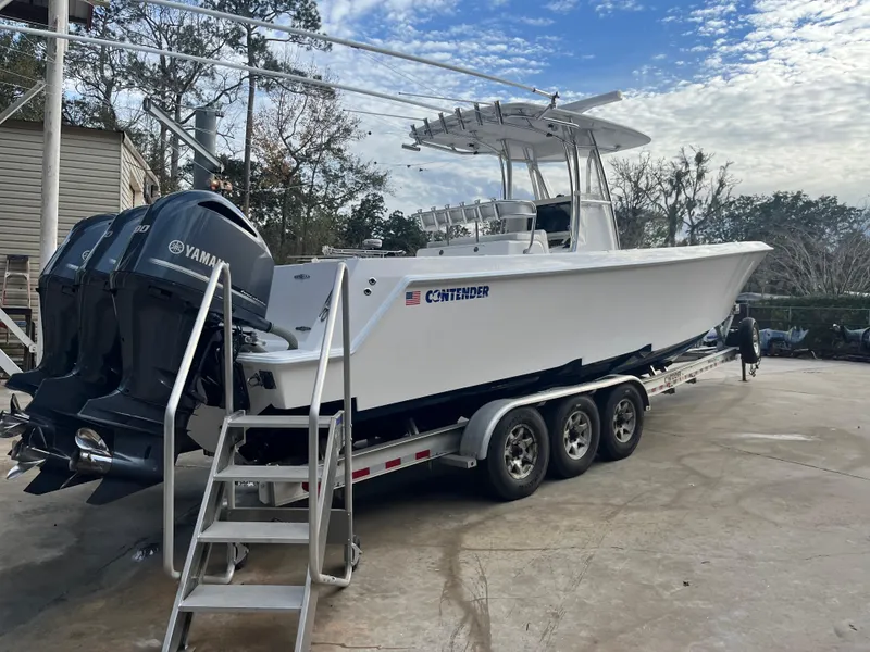 Slide: The Image of 2016 Contender 35 ST boat on trailer with Yamaha engines, parked outdoors. - 2