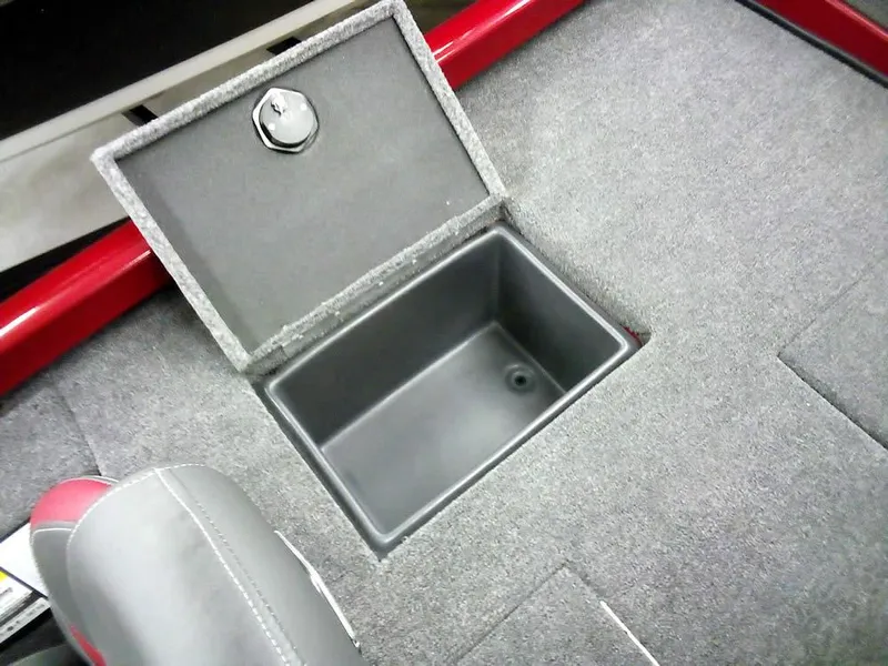 Slide: The Image of Ranger RT188C 2025 boat storage compartment with open lid, gray interior, and red trim. - 23