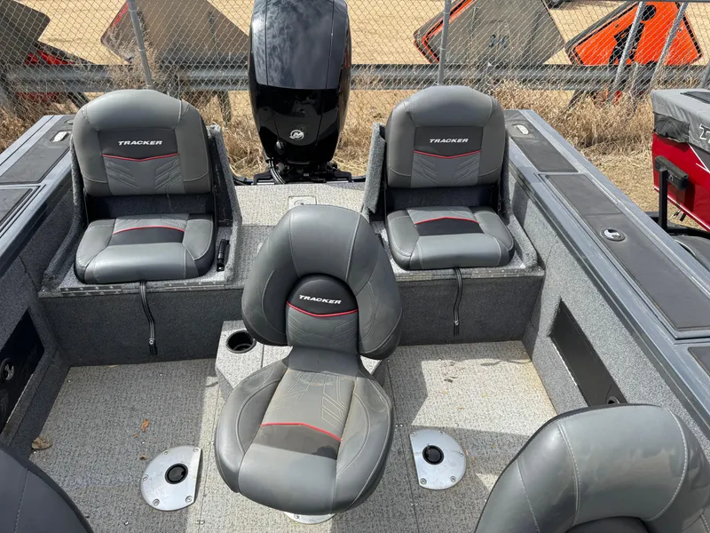 Slide: The Image of 2021 Tracker Targa V-18 Combo boat interior with four gray seats and motor. - 14
