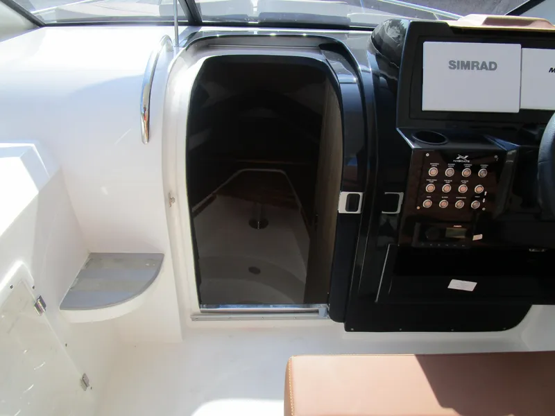 Slide: The Image of Interior view of 2025 NX Boats 290 cockpit with control panel and cabin entrance. - 11