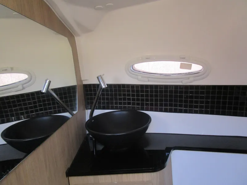 Slide: The Image of Modern bathroom interior of 2025 NX Boats 290 with sleek black sink and mirror. - 16