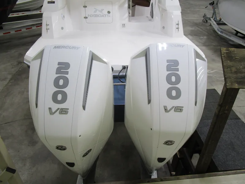 Slide: The Image of 2025 NX Boats 290 with twin Mercury 200 V6 outboard engines in a showroom. - 20
