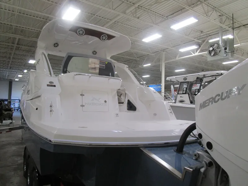 Slide: The Image of 2025 NX Boats 290 in showroom, featuring sleek design and Mercury engine. - 21
