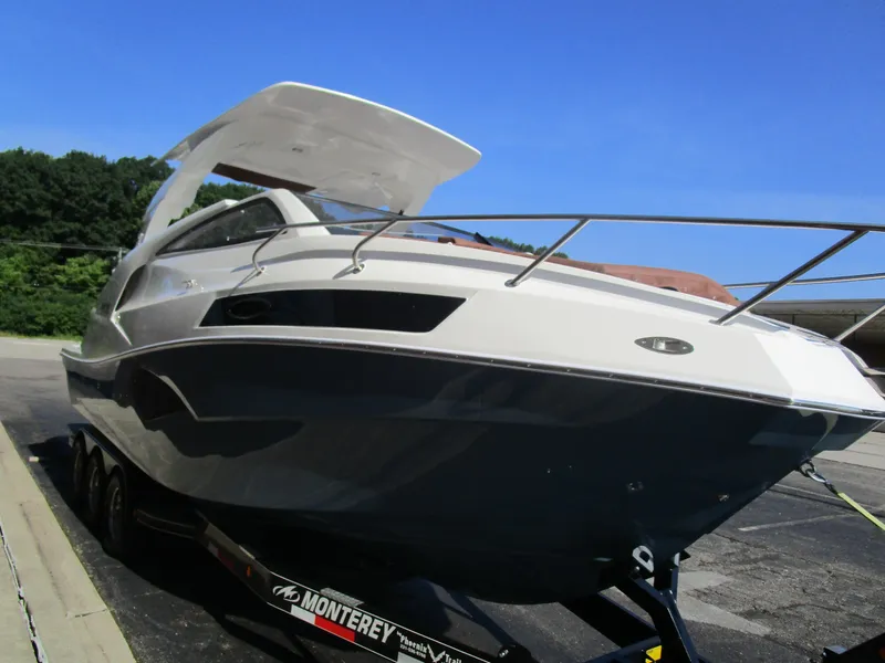 Slide: The Image of 2025 NX Boats 290 on trailer, sleek design, parked outdoors under clear blue sky. - 5