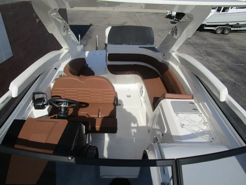 Slide: The Image of 2025 NX Boats 290 interior with brown seating and modern helm design. - 7