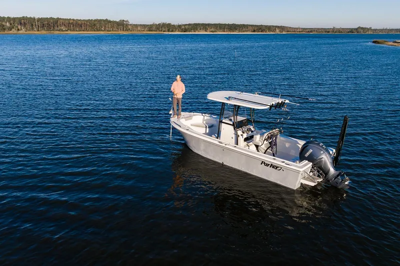 Slide: The Image of 2025 Parker 23 Special Edition boat on calm lake with person standing on deck. - 9