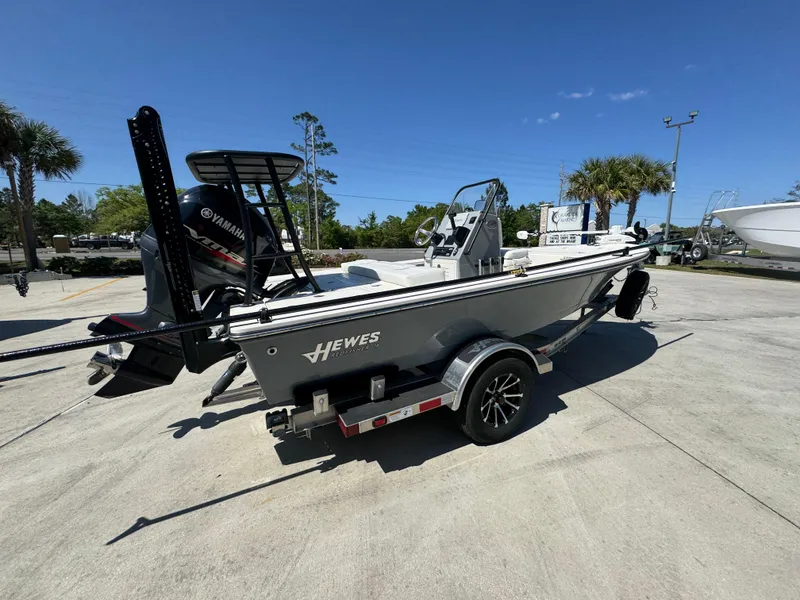 Slide: The Image of 2024 Hewes Redfisher 16 boat on trailer, parked outdoors under clear blue sky. - 10