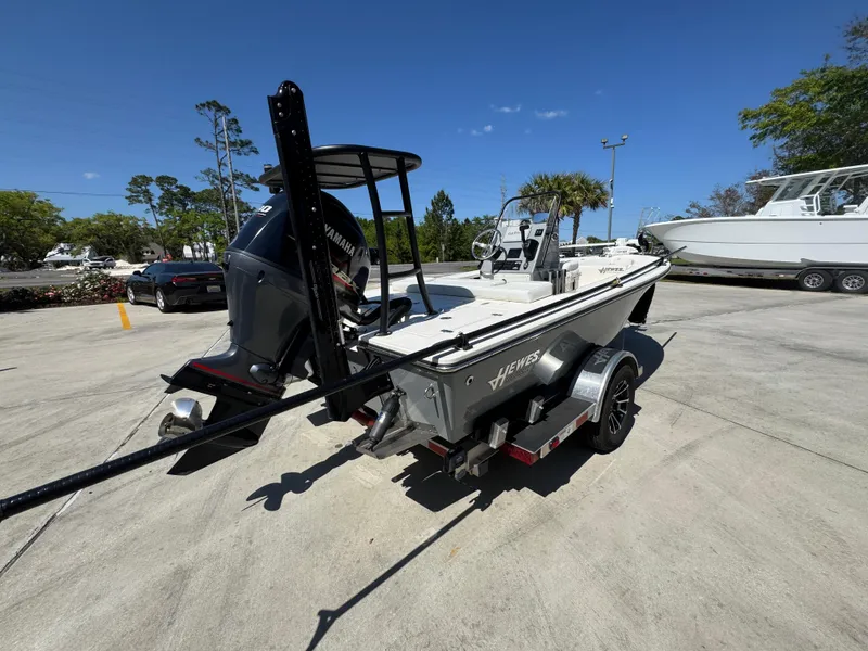 Slide: The Image of 2024 Hewes Redfisher 16 boat on trailer, parked outdoors under clear blue sky. - 11