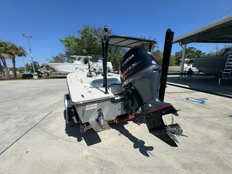 Slide: The Image of 2024 Hewes Redfisher 16 boat with Yamaha outboard motor, parked outdoors. - 14