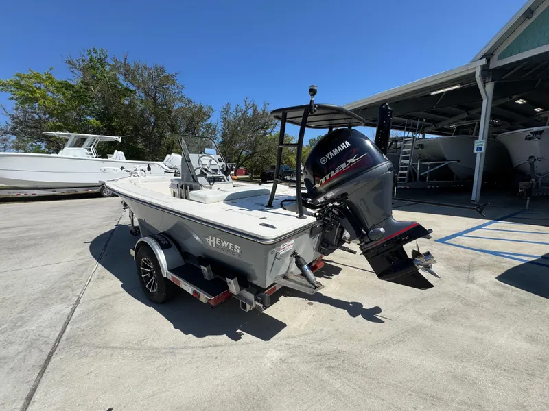 Slide: The Image of 2024 Hewes Redfisher 16 boat with Yamaha engine on trailer, parked outdoors. - 15