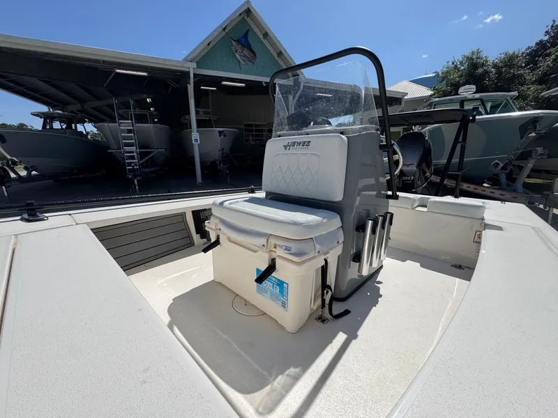 Slide: The Image of 2024 Hewes Redfisher 16 boat interior with seating and console, parked outdoors. - 19