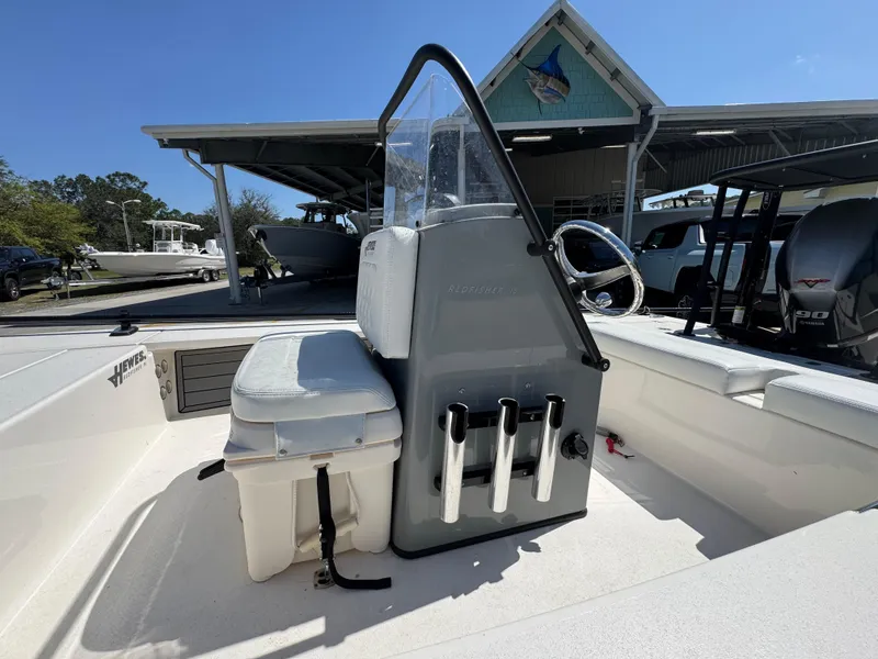 Slide: The Image of 2024 Hewes Redfisher 16 boat interior with console and seating, under a sunny sky. - 20