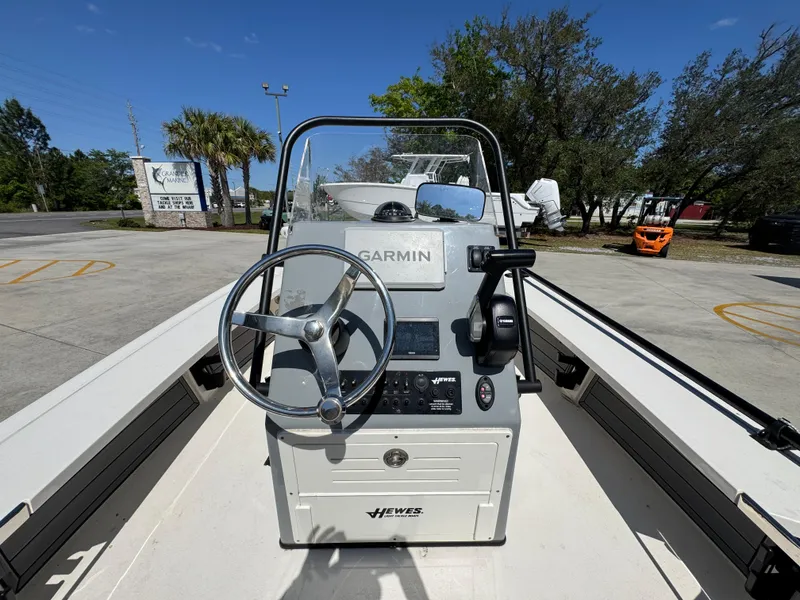 Slide: The Image of 2024 Hewes Redfisher 16 boat console with Garmin navigation system, steering wheel, and controls. - 23