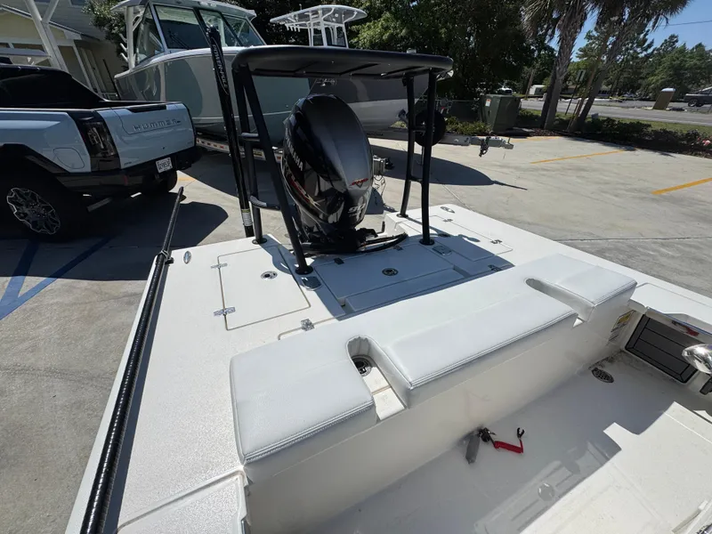 Slide: The Image of 2024 Hewes Redfisher 16 boat with outboard motor, parked in a sunny lot. - 25