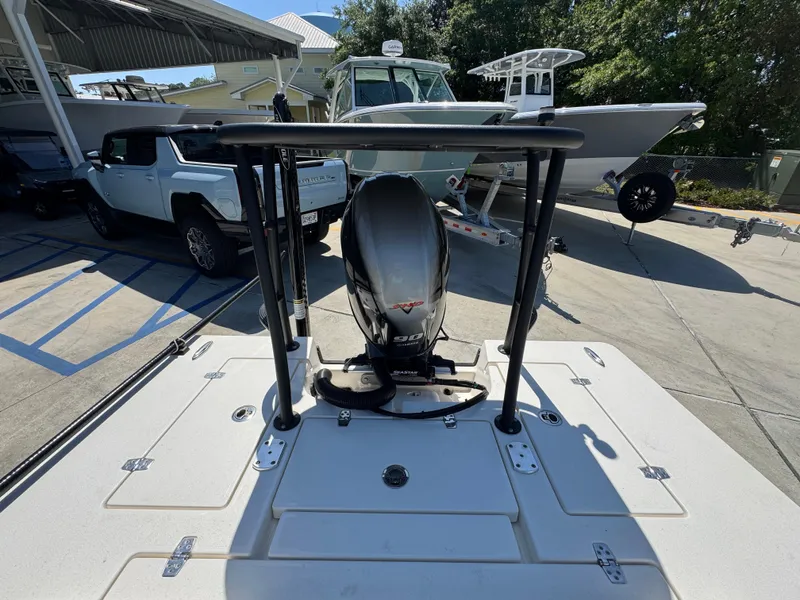 Slide: The Image of 2024 Hewes Redfisher 16 boat with motor, parked outdoors near other vehicles. - 27