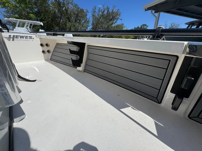 Slide: The Image of 2024 Hewes Redfisher 16 boat interior with storage compartments and rod holders. - 29
