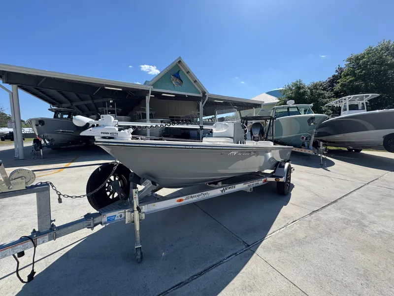 Slide: The Image of 2024 Hewes Redfisher 16 boat on trailer, parked outdoors under clear blue sky. - 3