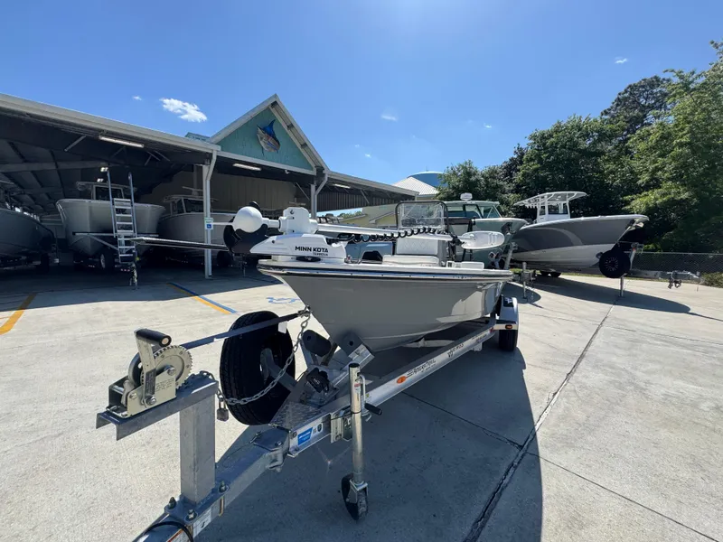 Slide: The Image of 2024 Hewes Redfisher 16 boat on trailer, parked outdoors under clear blue sky. - 4