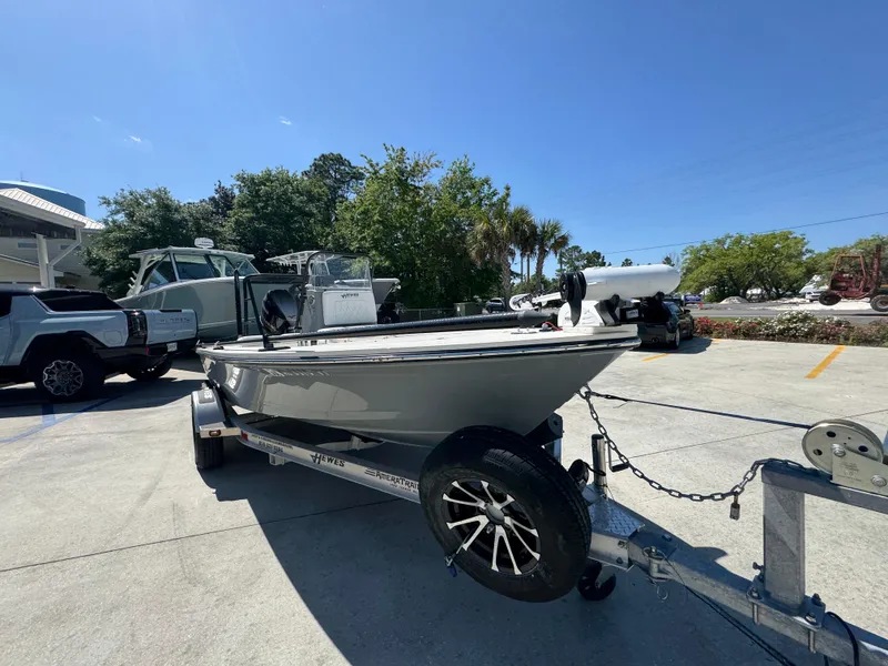 Slide: The Image of 2024 Hewes Redfisher 16 boat on trailer, parked outdoors under clear blue sky. - 6