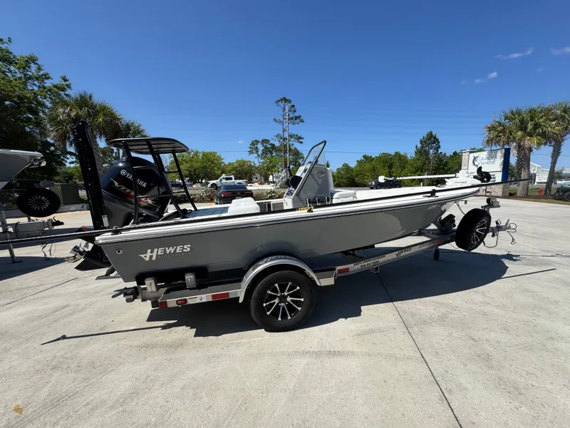 Slide: The Image of 2024 Hewes Redfisher 16 boat on trailer, parked outdoors under clear blue sky. - 9