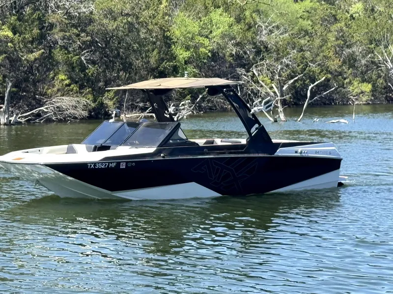 Slide: The Image of 2020 ATX Surf Boats 24 Type-S on a calm lake with lush greenery. - 0