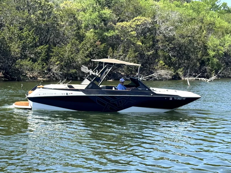 Slide: The Image of 2020 ATX Surf Boats 24 Type-S on a scenic lake with lush greenery. - 1