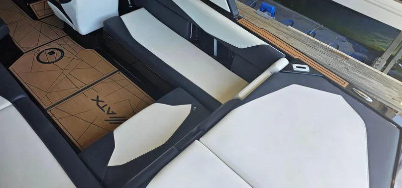 Slide: The Image of 2020 ATX Surf Boats 24 Type-S interior with white and black seating, brown flooring. - 13