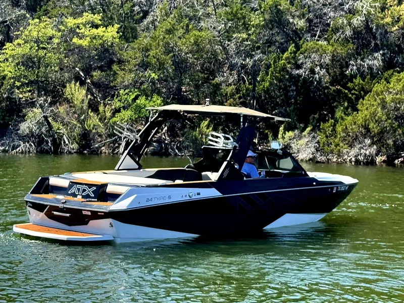 Slide: The Image of 2020 ATX Surf Boats 24 Type-S on a scenic lake with lush greenery. - 2