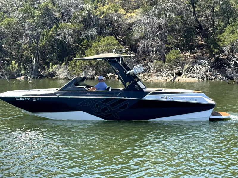 Slide: The Image of 2020 ATX Surf Boats 24 Type-S on a serene lake with lush greenery. - 3