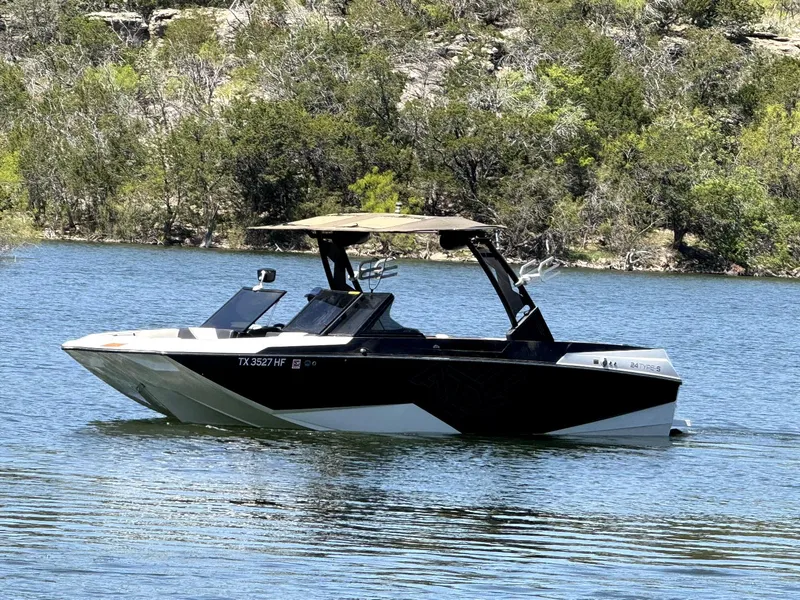 Slide: The Image of 2020 ATX Surf Boats 24 Type-S on a serene lake with lush greenery. - 4