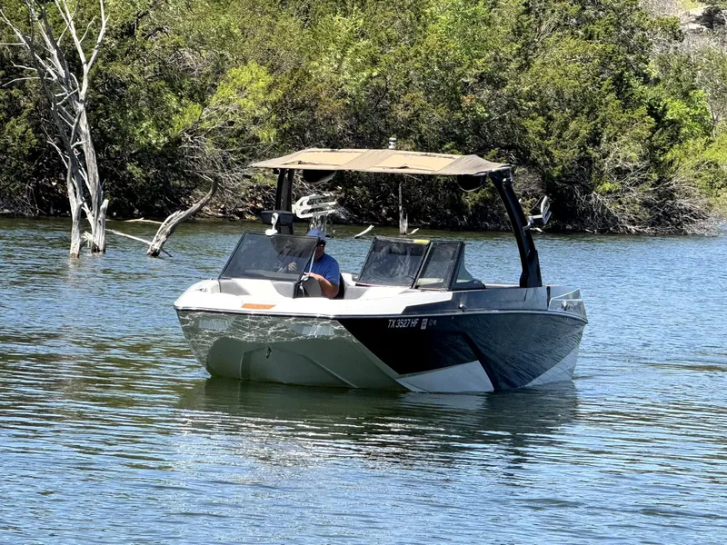 Slide: The Image of 2020 ATX Surf Boats 24 Type-S on a calm lake with lush greenery. - 5