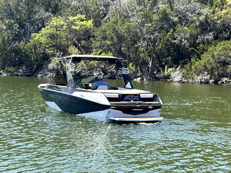 Slide: The Image of 2020 ATX Surf Boats 24 Type-S on a scenic lake with lush greenery. - 6