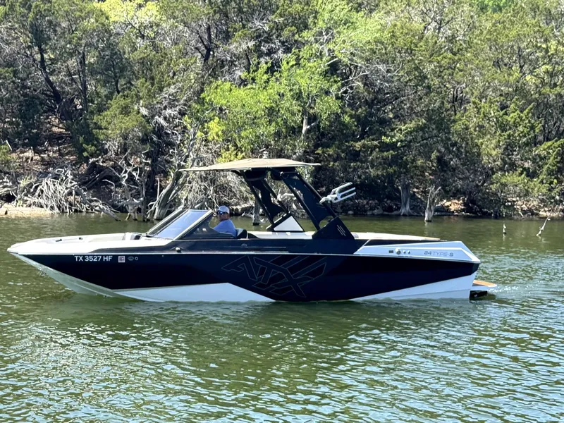 Slide: The Image of 2020 ATX Surf Boats 24 Type-S on a serene lake with lush greenery. - 7