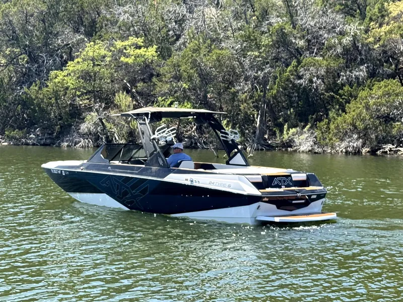 Slide: The Image of 2020 ATX Surf Boats 24 Type-S on a scenic lake with lush greenery. - 9