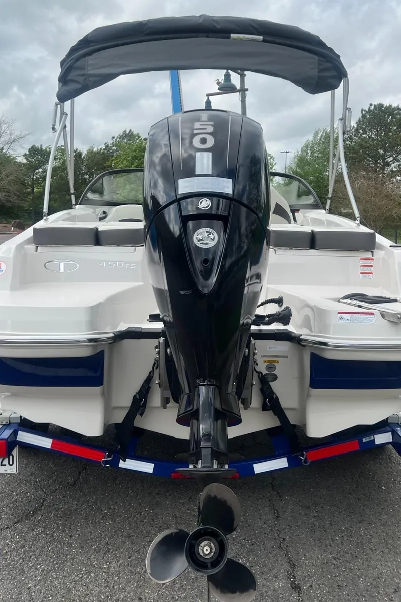 Slide: The Image of 2016 Tahoe TAH450TS boat with outboard motor, parked on a trailer. - 2