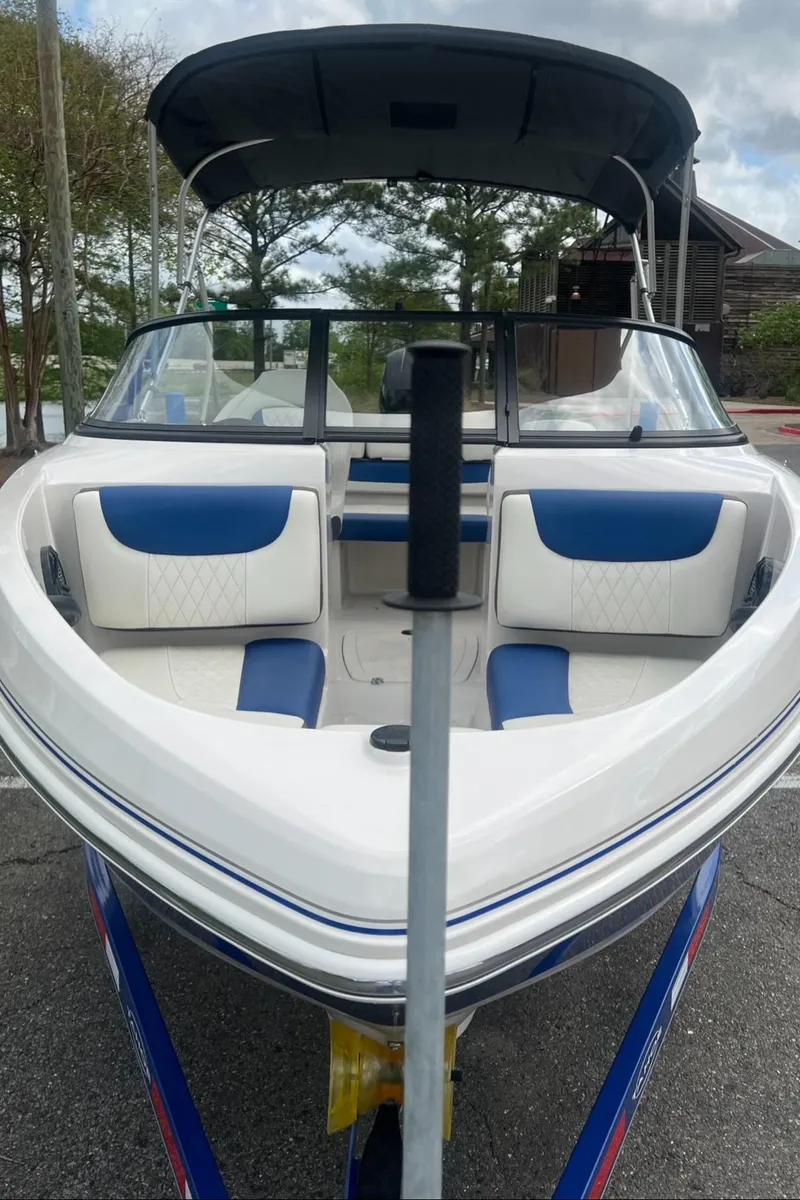Slide: The Image of 2016 Tahoe TAH450TS boat with blue and white seating, parked outdoors. - 9