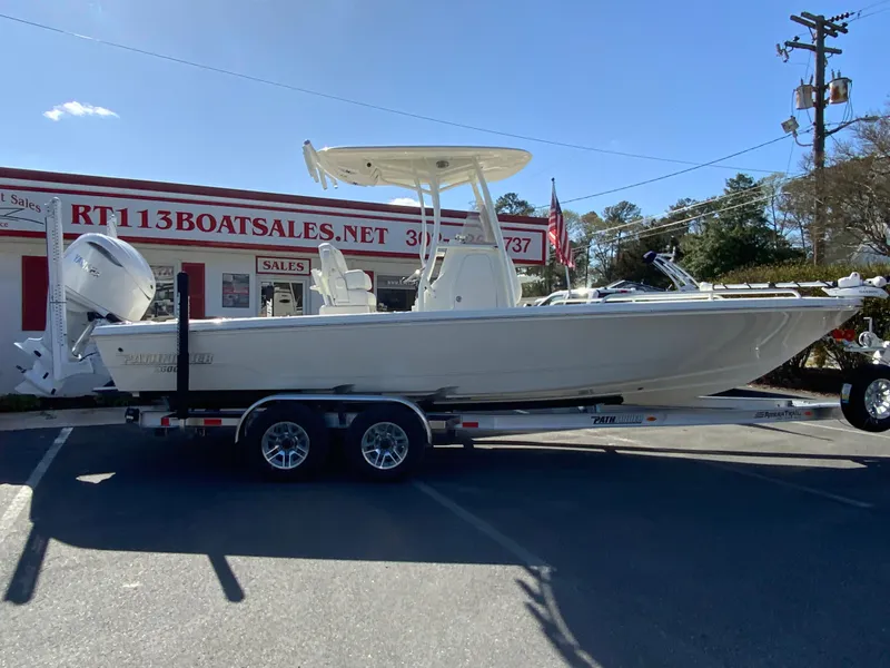The Image of 2025 Pathfinder 2600 TRS boat on trailer outside dealership, sunny day. - 1