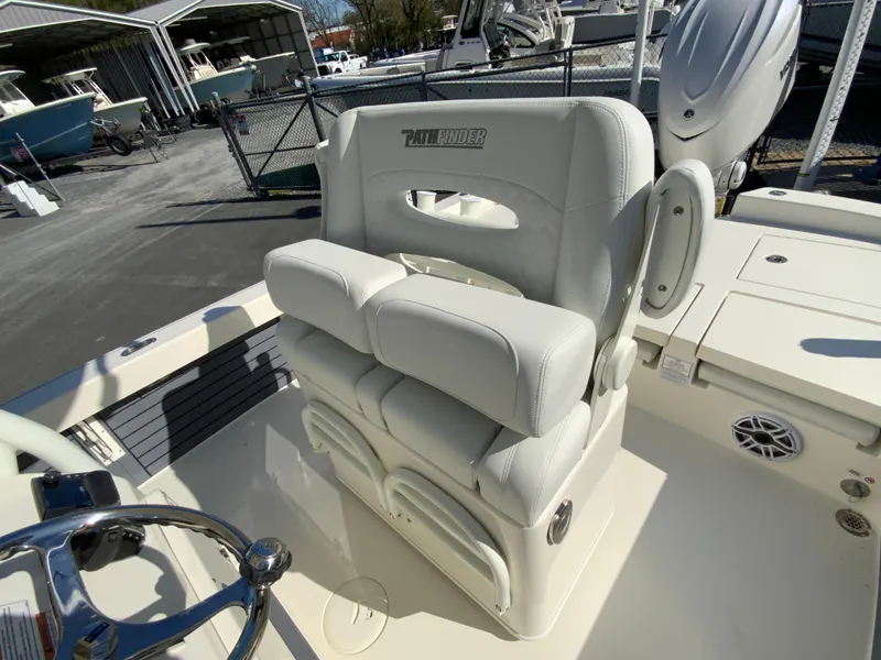 Slide: The Image of 2025 Pathfinder 2600 TRS boat seat, white upholstery, in a marina setting. - 13